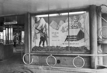 836137 Afbeelding van een etalage met reclame voor wintersport bij de ingang naar de buurtsporen van het N.S.-station ...